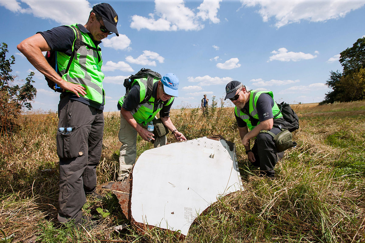 Holenderscy i australijscy policjanci badający szczątki samolotu Fot. Ministerie van Defensie/Wikimedia Commons